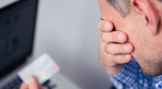Dejected man holding credit card