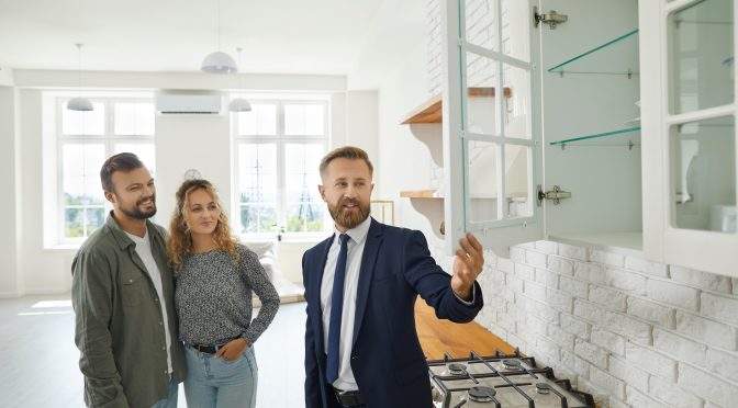 estate agent and couple in new home