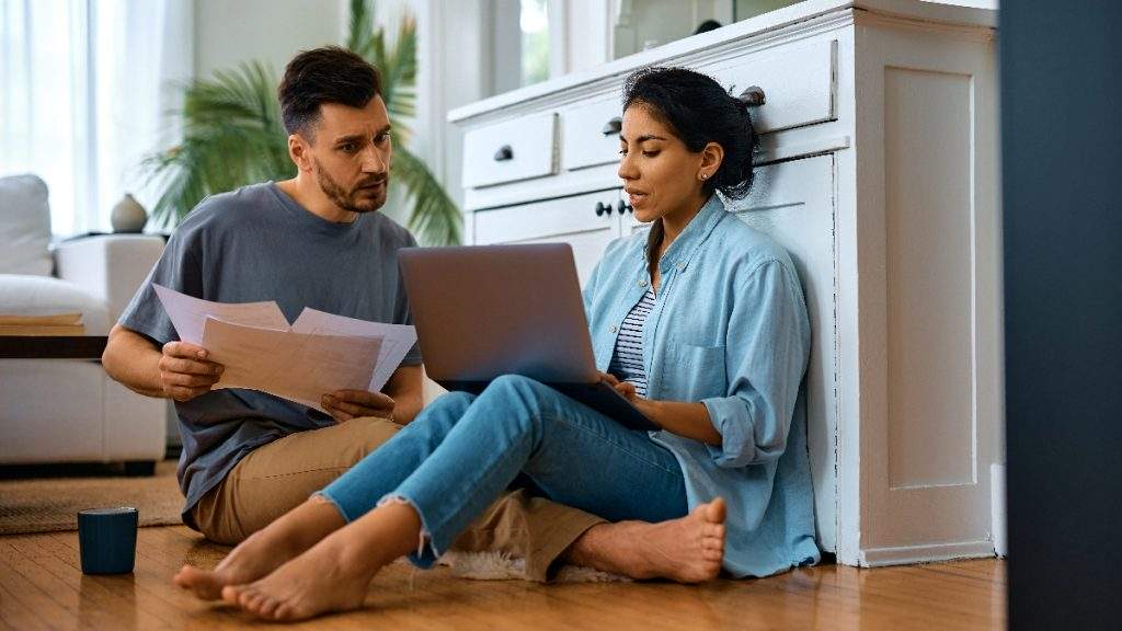 Couple sat on kitchen floor checking documents_16x9